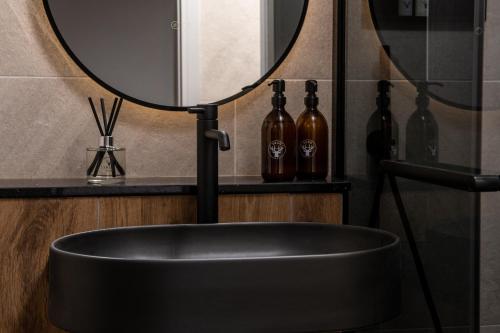 a black tub in a bathroom with a mirror at Montgomery House Apart-Hotel in Headingley