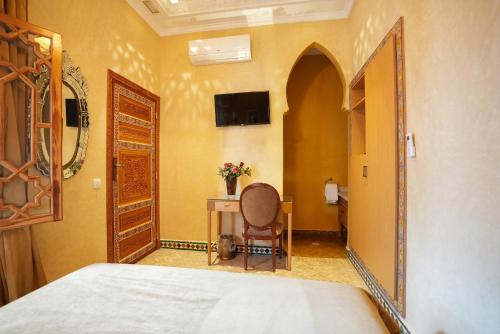 a bedroom with a bed and a table and a mirror at Palais Zahia Hotel & Spa in Tangier