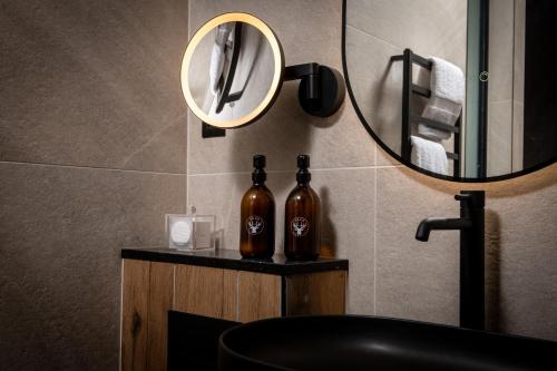 two bottles of wine sitting on a counter under a mirror at Montgomery House Apart-Hotel in Headingley