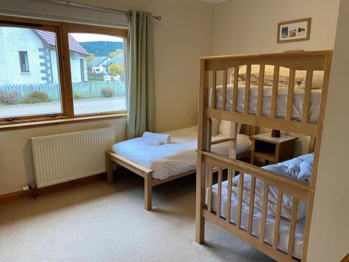 a bedroom with two bunk beds and a window at Dalfaber House Luxury holidays in the Highlands in Aviemore