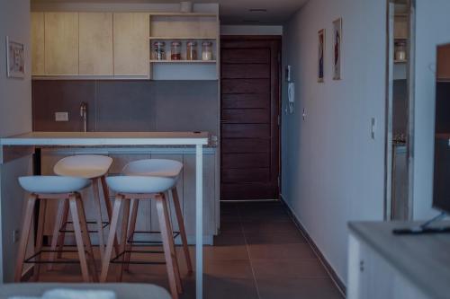 eine Küche mit zwei Barhockern und einer Theke in der Unterkunft Gente del Sur - Buena Vista in Ushuaia