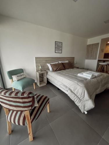 a bedroom with a large bed and a chair at Gente del Sur - Buena Vista in Ushuaia
