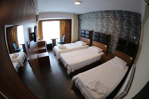 a hotel room with two beds and a window at Bayraktar Hotel in Akcakoca