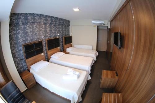 a hotel room with two beds and a tv at Bayraktar Hotel in Akcakoca