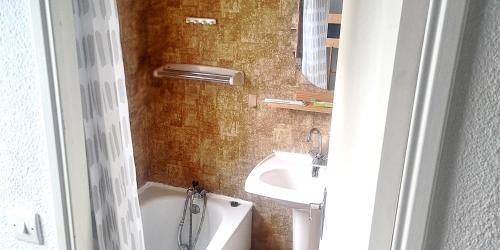a bathroom with a sink and a tub and a toilet at Maisonnette 2 pièces Mezzanine 4 pers avec piscine extérieure chauffée ADELA in Guidel