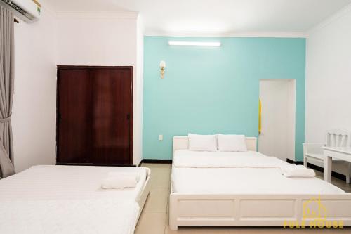 two beds in a room with blue walls at Mayhouse Vũng Tàu Hotel TPVT in Vung Tau