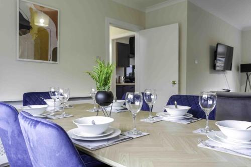 a table with chairs and wine glasses on it at Cochran House in Bathgate