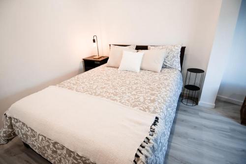 a bedroom with a bed with white sheets and pillows at Casa das Pôpas in A dos Cunhados