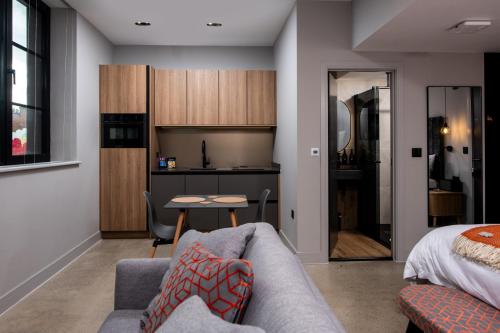 a living room with a couch and a bed and a kitchen at Montgomery House Apart-Hotel in Headingley