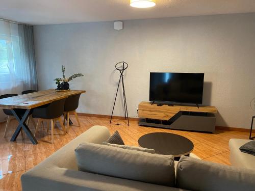 a living room with a couch and a flat screen tv at Ferienwohnung 3 Schweizer in Fützen
