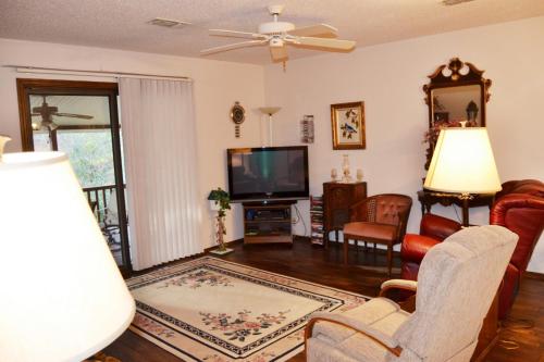 un soggiorno con TV, divano e sedie di 23 Tomisa Lane a Hot Springs Village