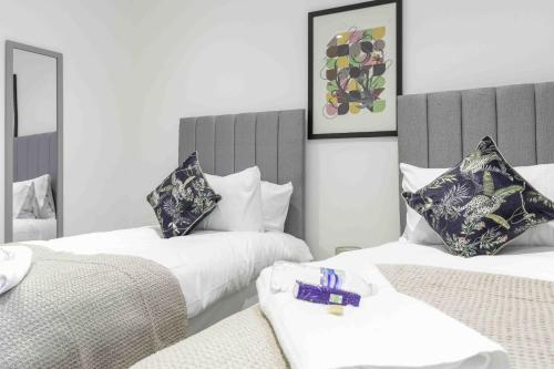 a bedroom with two beds with purple packets on them at Strath Apartment in Strathaven