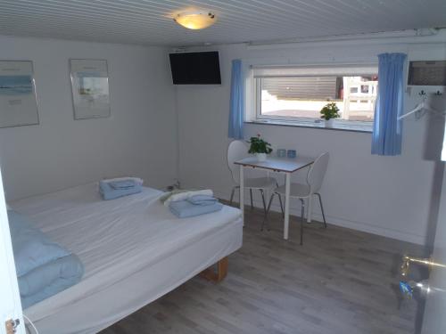 a bedroom with a bed and a table and a window at Oddevej 20 Skagen in Skagen