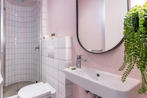 a bathroom with a sink and a toilet and a mirror at Flamingo 407 - Central Prime Sea Point Apartment in Cape Town