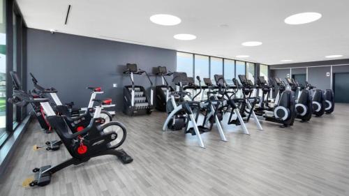 a gym with a row of exercise bikes and treadms at Hollywood Luxury Retreat I Pool Views I Jacuzzi I Fitness Center I Free Parking! in Los Angeles