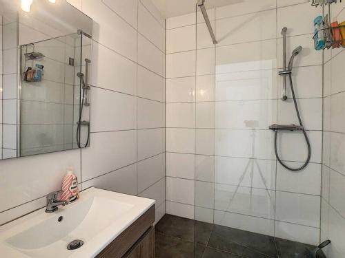 une salle de bain blanche avec un lavabo et une douche dans l'établissement Studio Clara - proche gare et aéroport, balcon, à Village-Neuf