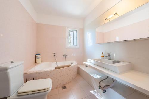 a bathroom with a tub and a sink and a toilet at Studio Salvia in Katávolos