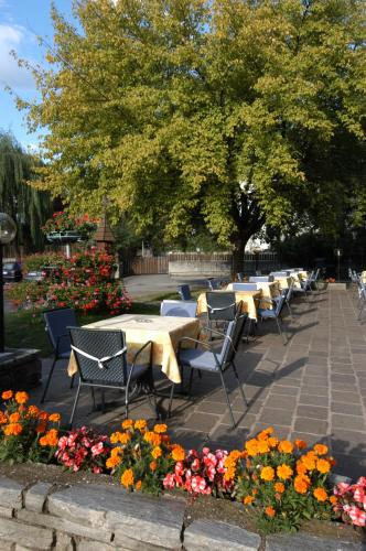 a row of tables and chairs in a park with flowers at Hotel & Residence Sylvanerhof in Chiusa