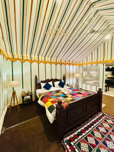 a bedroom with a bed in a tent at Venture Desert Camp Jaisalmer in Jaisalmer