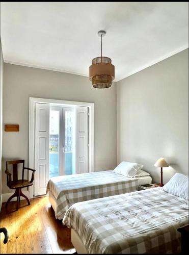 a bedroom with two beds and a pendant light at Porto Vintage House in Porto
