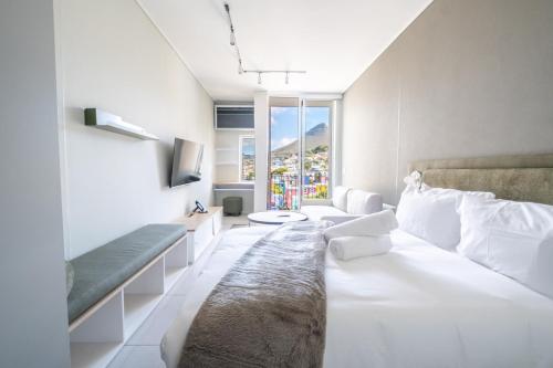 a living room with a large bed and a large window at The Rose 602: Modern City Apartment with Views in Cape Town