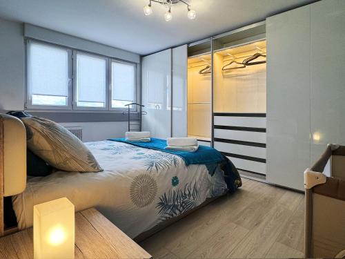 a bedroom with a bed in a room with windows at Chez Vélia Grand 4 pièces, parking privé et emplacement idéal in Strasbourg