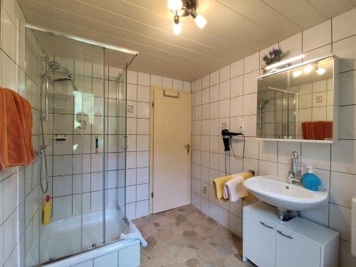 a bathroom with a sink and a shower and a tub at Haus Daheim in Bad Hindelang