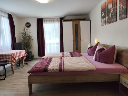 a bedroom with a large bed with purple sheets at Haus Daheim in Bad Hindelang