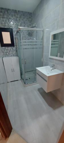 Un baño con ducha de cristal y lavabo. en Ahlem, en Tabarka