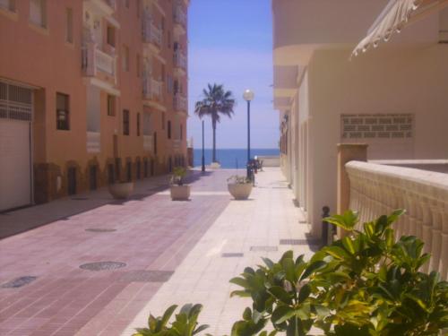 a street with buildings and the ocean in the background at Macavi in Rota