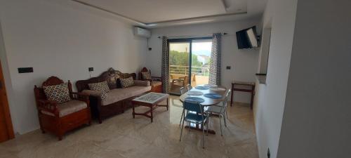 Una sala de estar con un sofá, una mesa y sillas. en Ahlem, en Tabarka
