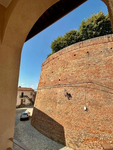 a brick wall with a car parked in a parking lot at Takámüsica- appartamenti in Cisterna dʼAsti