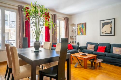 un salon avec une table et un canapé bleu dans l'établissement Creative Artist's Retreat in Paris, à Paris