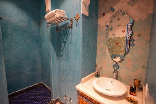 a bathroom with a sink and a mirror at Palais Zahia Hotel & Spa in Tangier