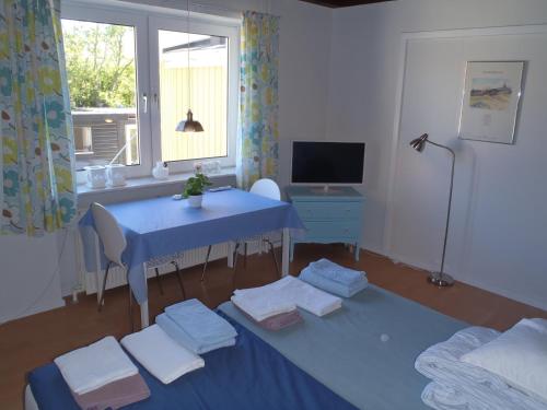 een kamer met een blauwe tafel, een bureau en een raam bij Oddevej 20 Skagen in Skagen