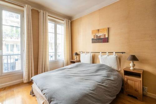 une chambre avec un grand lit et deux fenêtres dans l'établissement Creative Artist's Retreat in Paris, à Paris