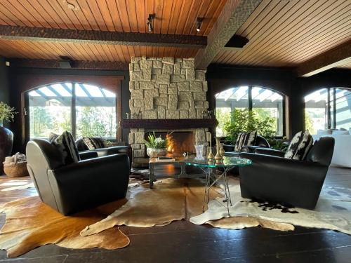 a living room with couches and a stone fireplace at Alma Hotel in Campos do Jordão