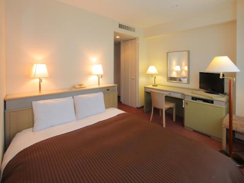 a hotel room with a bed and a desk at Hotel Green Tower Makuhari in Chiba