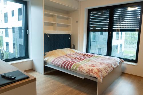 Un dormitorio con una cama y dos grandes ventanales. en Ella's Cozy place, en Liubliana