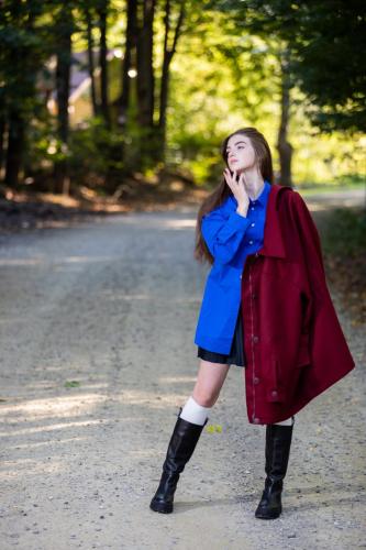 a woman talking on a cell phone while standing on a road at Casa Octavian in Suceviţa