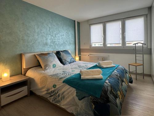 a bedroom with a bed with two towels on it at Chez Vélia Grand 4 pièces, parking privé et emplacement idéal in Strasbourg