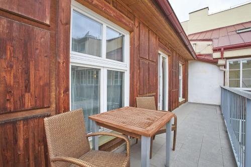 a patio with a wooden table and chairs on a balcony at Wenceslas Square Residence in Prague