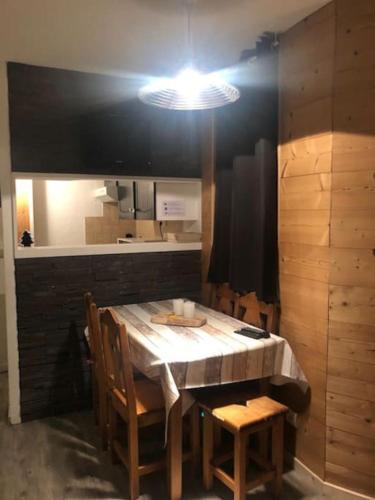une salle à manger avec une table, des chaises et une lampe dans l'établissement L'appartement Emma d'Avoriaz, à Avoriaz
