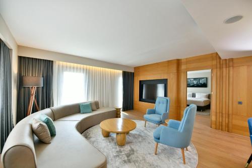 a living room with a couch and blue chairs at Radisson Hotel Mersin in Mersin