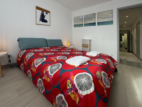 a bedroom with a large bed with a red blanket at Chez Vélia Grand 4 pièces, parking privé et emplacement idéal in Strasbourg
