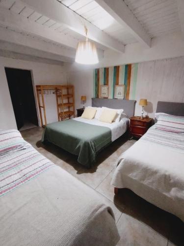 a bedroom with two beds and a chandelier at Cabañas Seru in El Bolsón