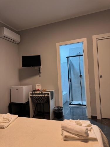a bedroom with a bed and a desk and a television at Reale Guest House in Mascalucia