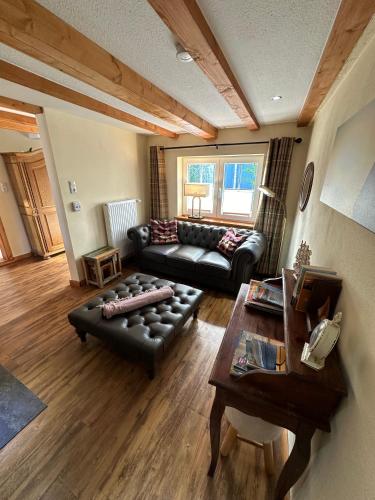 a living room with a leather couch and a table at Little Blue Cottage #9 in Fehmarn