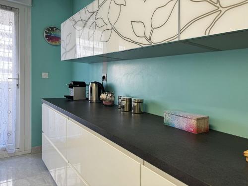 a kitchen with a black and white counter top at Chez Vélia Grand 4 pièces, parking privé et emplacement idéal in Strasbourg