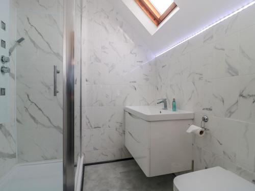un bagno bianco con doccia e lavandino di 4 Noel Court a Chipping Campden
